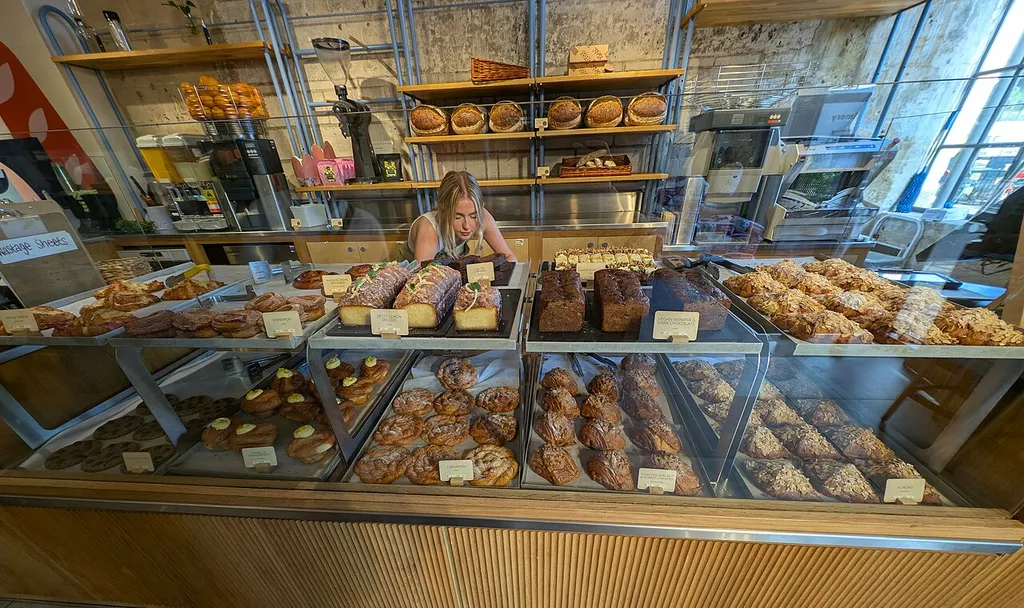 mostrador de panadería con bollería, bizcochos y panes en las estanterías